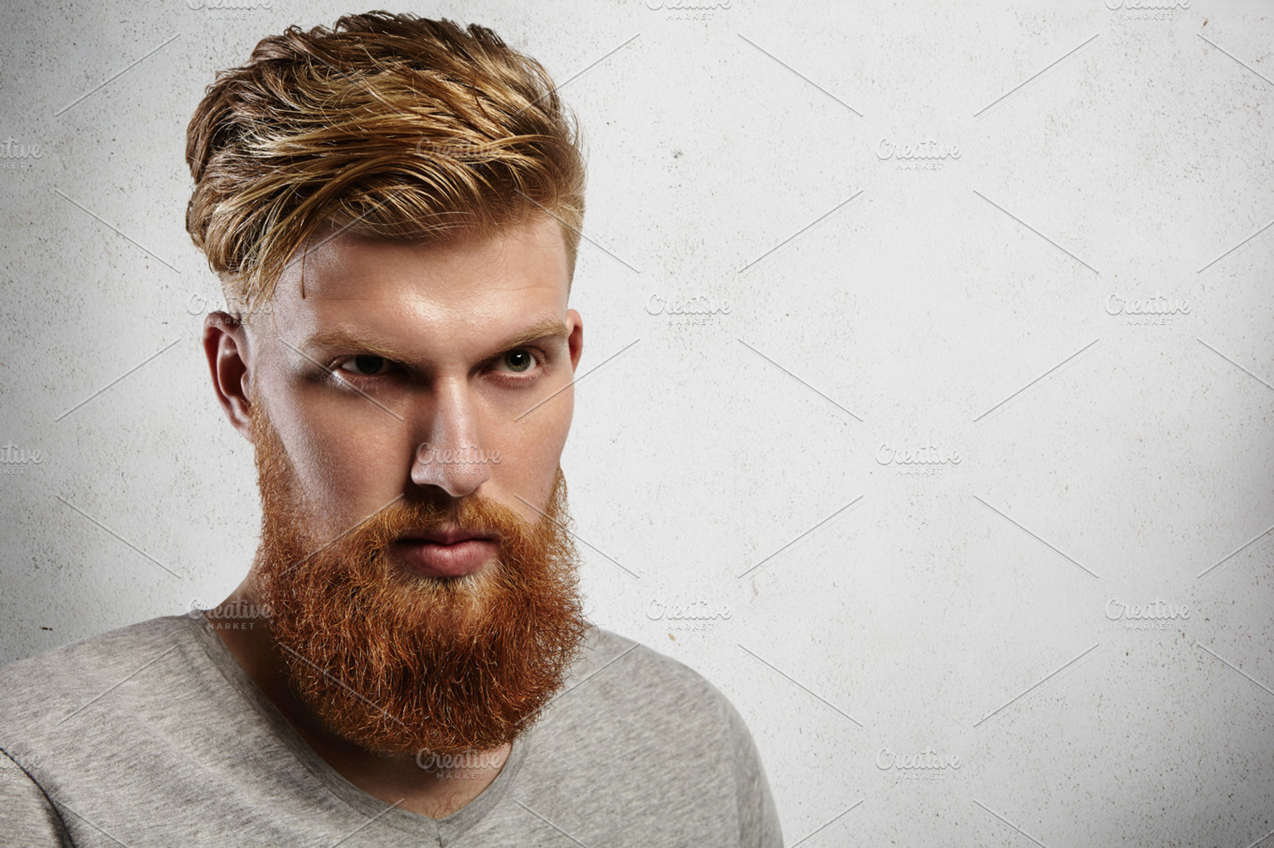 portrait of young european hipster with fair skin and trendy ginger beard.  fashionable undercut hairstyle and handsome face features together with