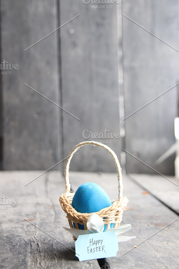 Happy Easter Blue Egg On Rustic Table And A Basket With A Tag