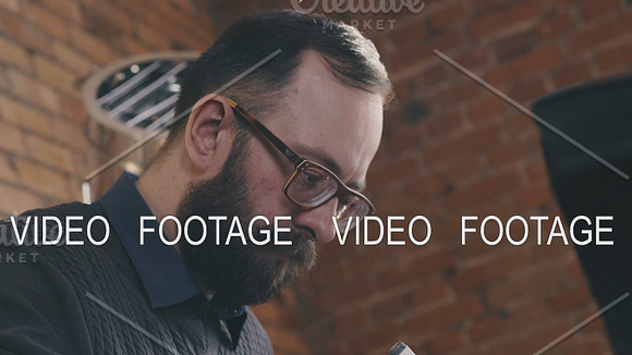 Stylish Man With A Beard And Glasses Works In A Loft-style Office