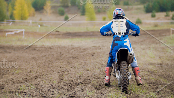 Motocross racer start riding his dirt Cross MX bike - rear view in Graphics