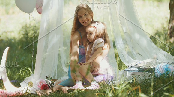 Mother and daughter hugging in park - picnic and birthday in Graphics