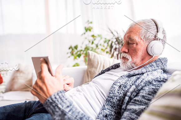 Senior Man With Tablet Relaxing At Home