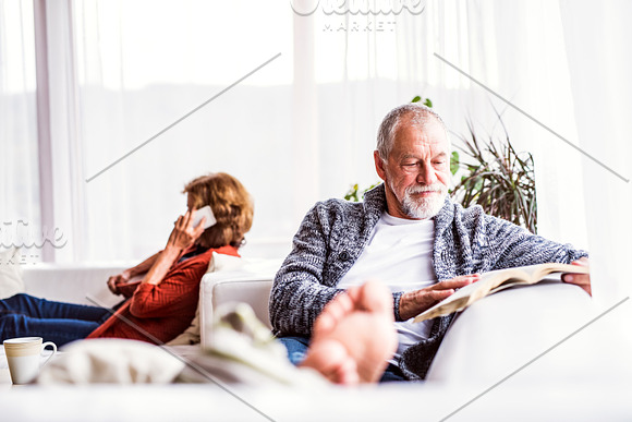 Senior Couple With Smartphone Relaxing At Home