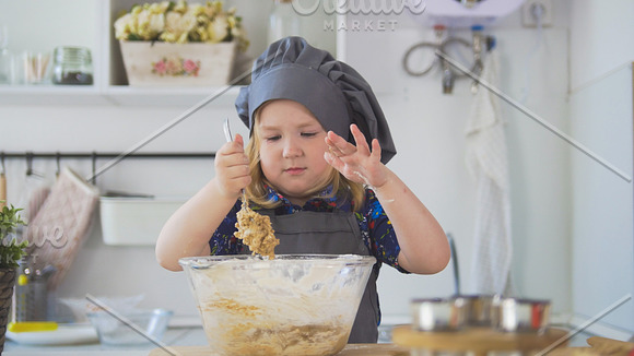 Girl baker mixes the mixture for cookies with a big spoon in Graphics