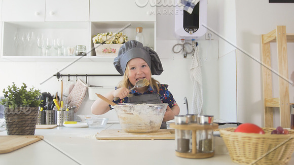 Preschool girl baker mixes the dough in a bowl in Graphics