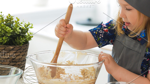 Girl baker mixes the mixture for cookies with a whisk in Graphics