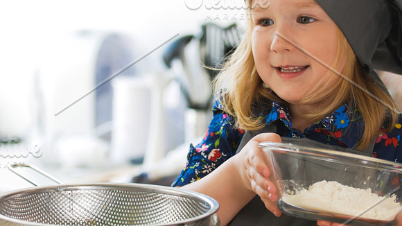 Cheerful little girl make cookies in the kitchen in Graphics