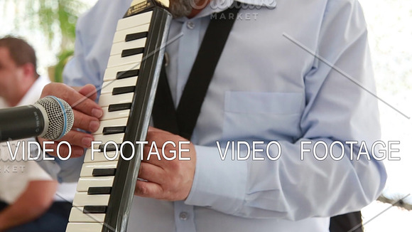 Close-up Of A Man Playing On The Musical Instrument MELODICA