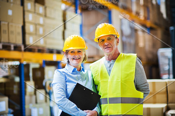 Senior Woman Manager And Man Worker Standing In A Warehouse